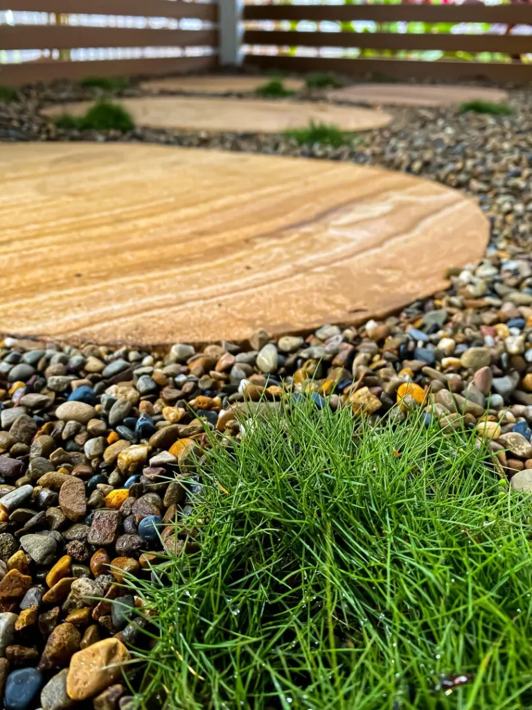 Pebble path with grass and wooden fence