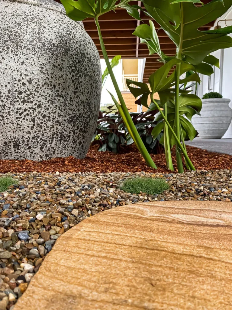 Garden with large stone vase and leafy plants