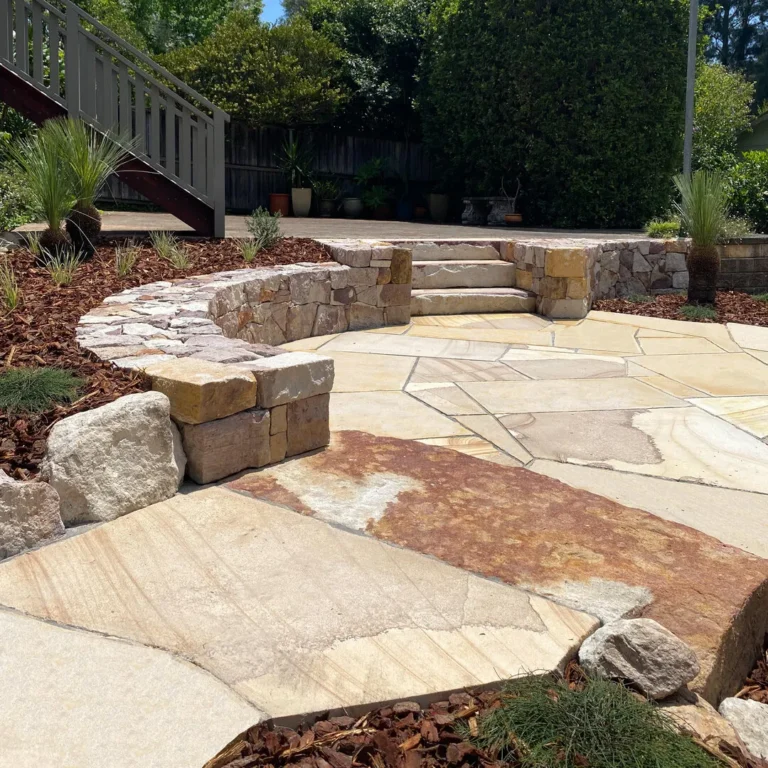 Stone patio with stairs and garden landscape.