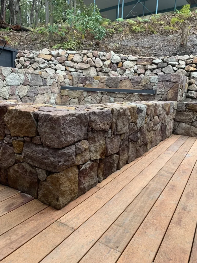 Stone retaining wall with wooden deck surface.