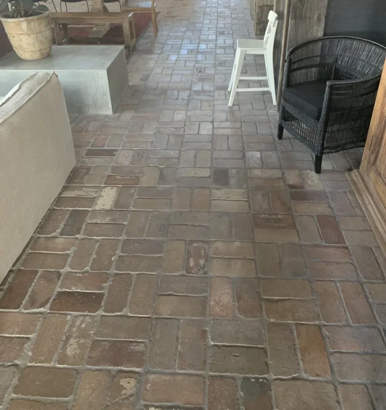 Rustic brick floor with chairs and table.