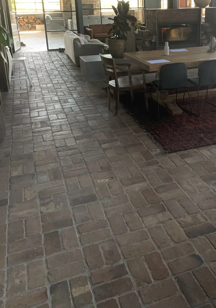 Cozy living room with brick floor and fireplace.