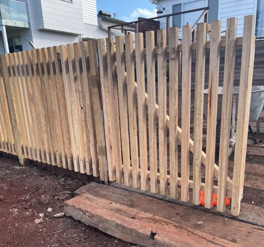 Wooden fence under construction near house