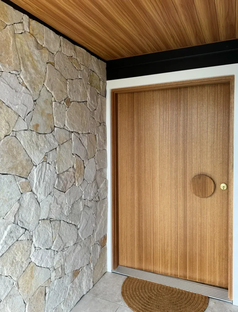 Wooden door with stone wall and mat.