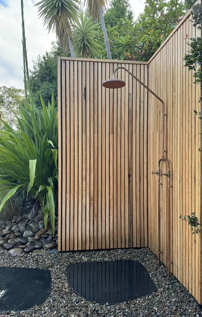 Outdoor wooden shower with tropical plants