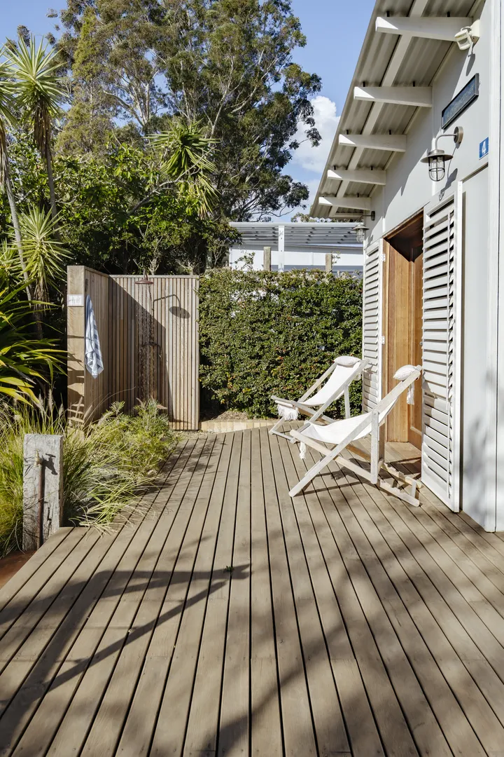 Wooden deck patio with lounge chairs and greenery