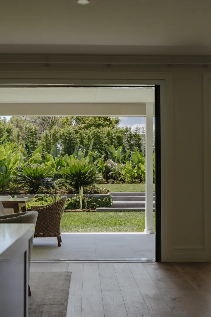 Open sliding door overlooking lush garden patio