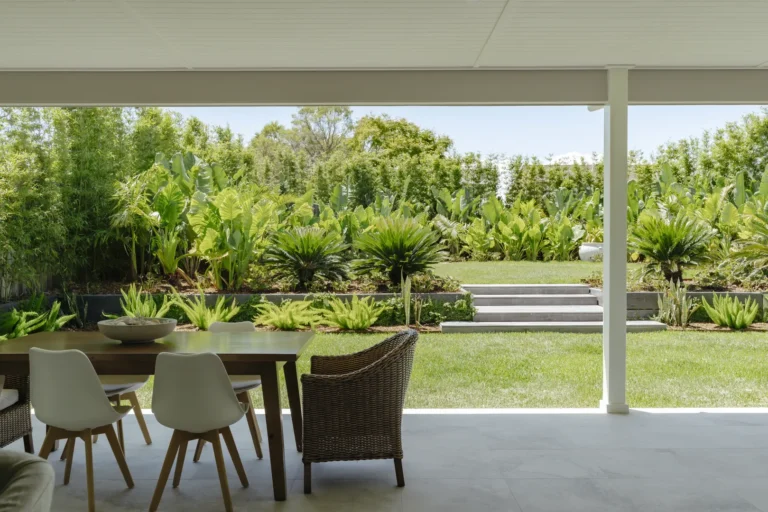 Covered patio overlooking lush tropical backyard garden