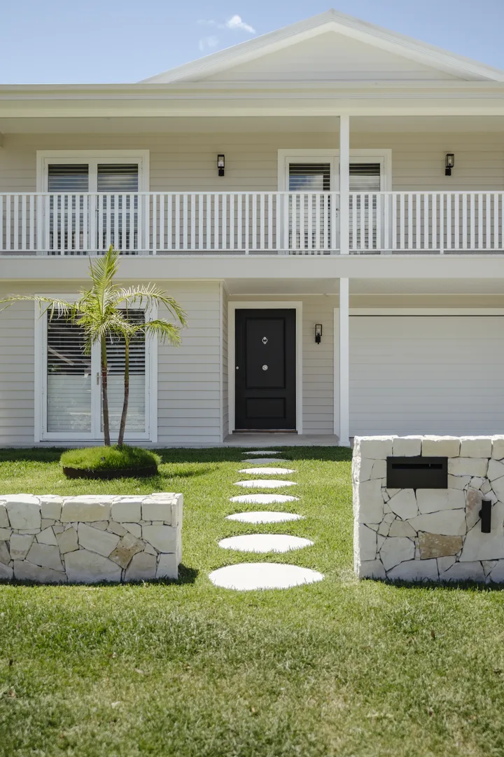 Modern two-story home with palm and stone path