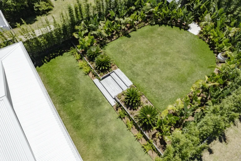 Aerial view of landscaped backyard with central garden beds