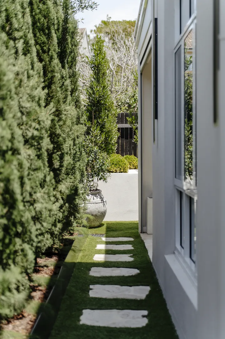 Narrow garden path with stepping stones and hedges