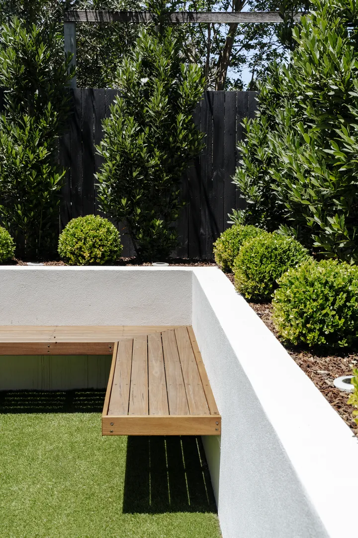 Modern garden bench with manicured shrubs