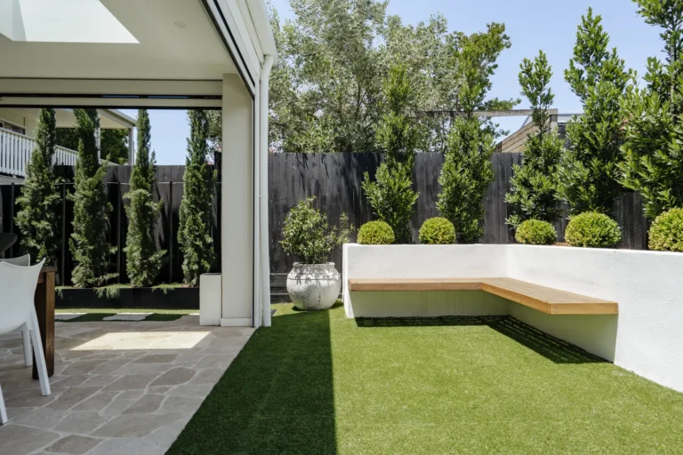 Modern backyard patio with built-in bench and greenery