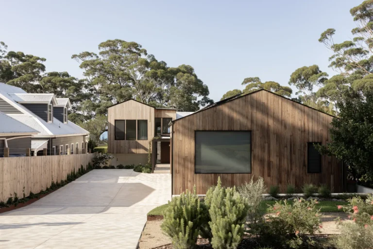 Modern wooden house with driveway and landscaped garden